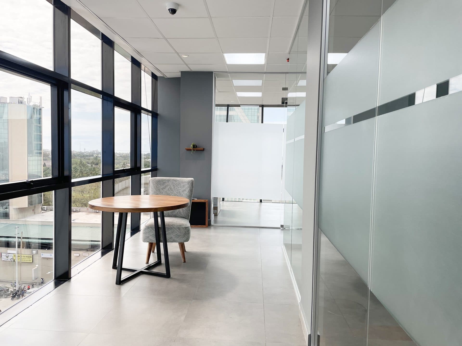 A round table by the windows at ZO Premium, beside the glazed offices